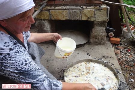 コソボで誇らしげに大きなフリアを焼いてくれたお母さん