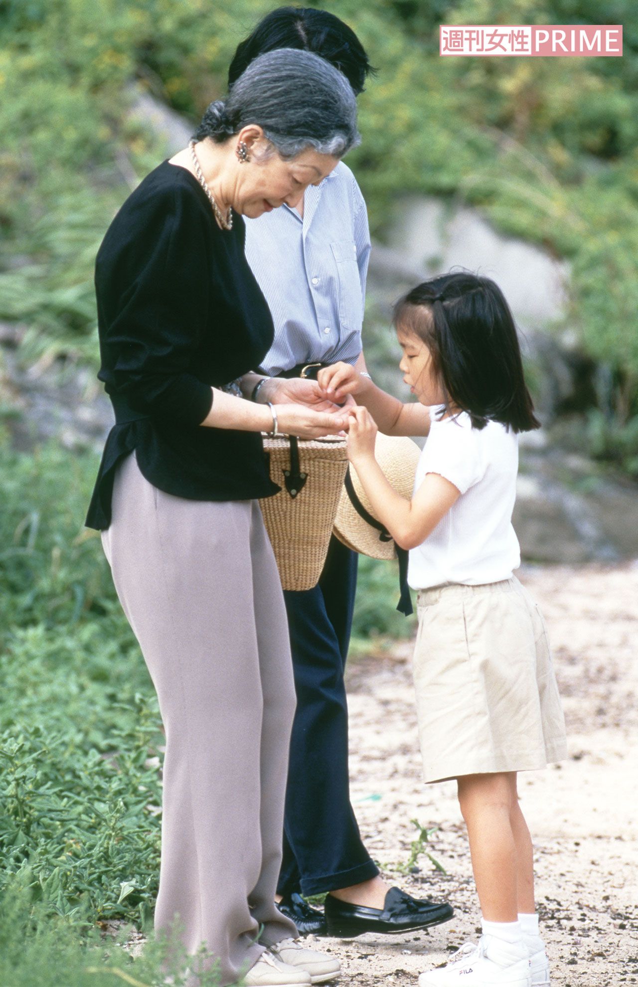 '98年8月、静岡県の須崎御用邸近くの浜辺で仲よく触れ合われる美智子さまと6歳の眞子さん