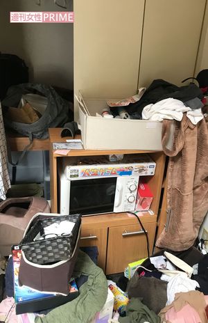 電子レンジの上に人生ゲーム。部屋は物であふれかえっていた