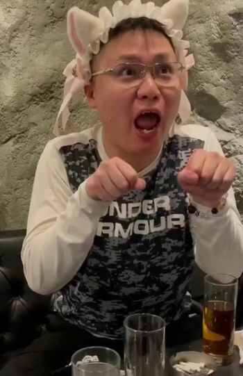 耳付きのカチューシャをつけて、ネコの真似をしておどける佐々木被告（関係者提供）