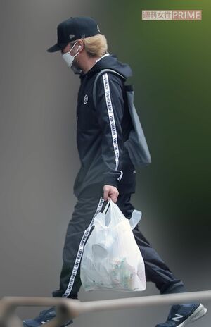 2024年4月中旬、食料を買い込んで自宅に帰る「スピードワゴン」小沢一敬。伸びきったヒゲがマスクの下からはみ出していた