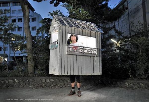 発泡スチロール製の白い家の中に身を置く村上さん。約1年間、この家を背負いながら国内180か所を移動してまわった。（撮影：Ken'ichiKikuchi）