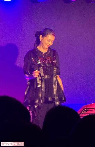 全身黒のコーデのシックな服にチャーミングな笑顔が映える