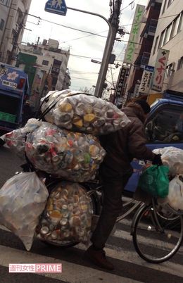 大量の空き缶を運ぶホームレス