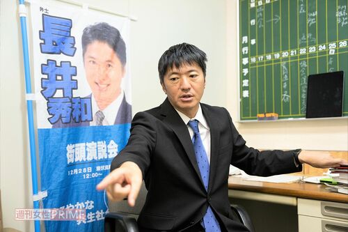 議員室で取材に応じる長井秀和