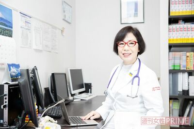 診察室の富永さん。バランスボールに座って診察するスタイル　写真／北村史成