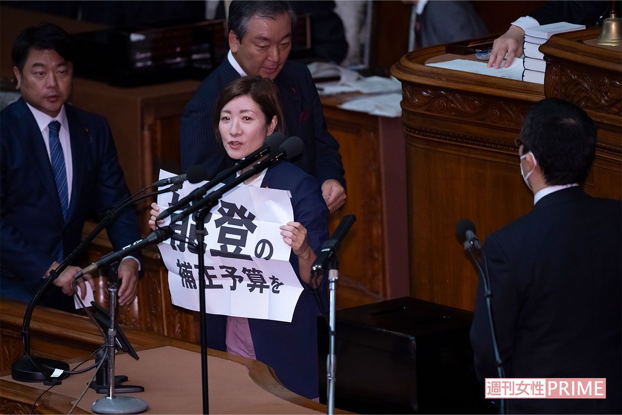 総理大臣指名選挙の投票中、突如壇上で「能登の補正予算を」と書かれた紙を掲げる大石あきこ氏（2024年10月1日、本誌写真班）