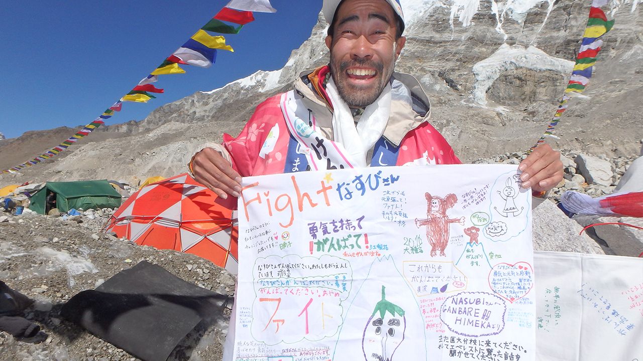 エベレストのベースキャンプで応援の寄せ書きを手にするなすび