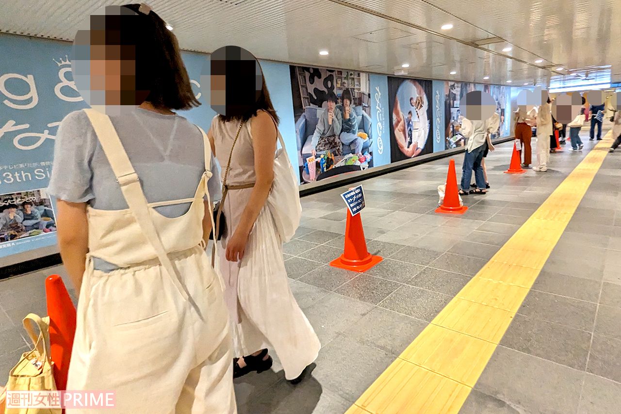 渋谷駅地下通路に展示されたKing & Prince『なにもの』巨大広告と記念撮影をするファン