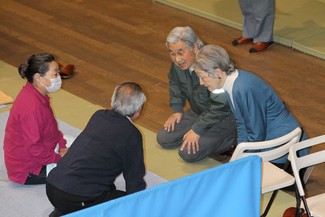 '11年3月　東京武道館で避難生活を送っている被災者を見舞われた両陛下。ひざをつき、同じ目線で励ます姿が印象的だった