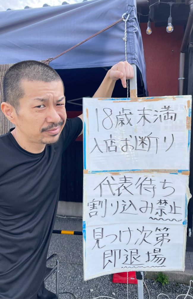 店主の三浦さんと店頭に掲げられた注意書き