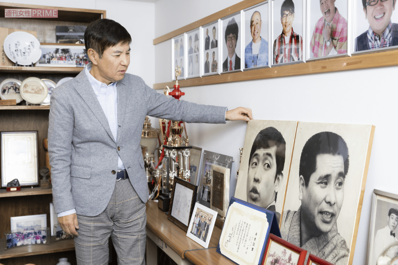 事務所の大先輩である萩本欽一、故・坂上二郎さんのパネルの前で。「要所要所で萩本さんからいただいたアドバイスのおかげでここまでくることができました」※撮影／矢島泰輔