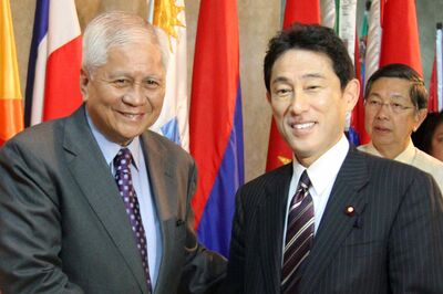 メガネをしていない10年前の岸田首相。フィリピンの外相と笑顔で握手をする姿が爽やかだ写真／共同通信社