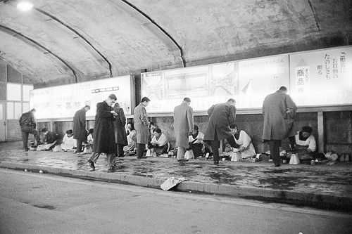 昭和30年代、靴磨きの光景。割ぽう着姿の女性も目立つ