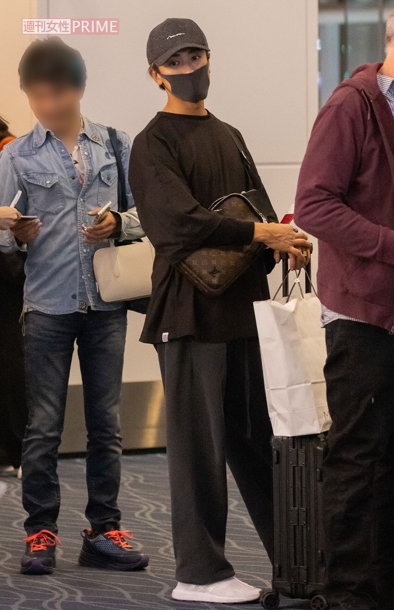 2023年11月、飛行機に搭乗する列に並ぶ赤西。手に持っている紙袋は、愛する家族へのお土産だろうか