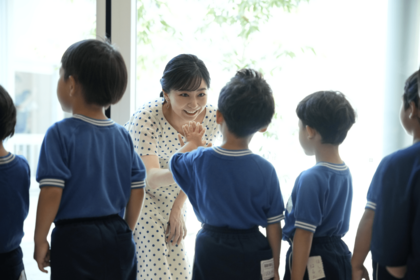 静岡県御殿場市の「高嶺の森のこども園」を訪れ、園児たちの遊びに加わりハイタッチで交流（2025年7月25日）