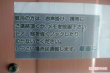 岡野母娘が住む部屋の玄関ドアの張り紙
