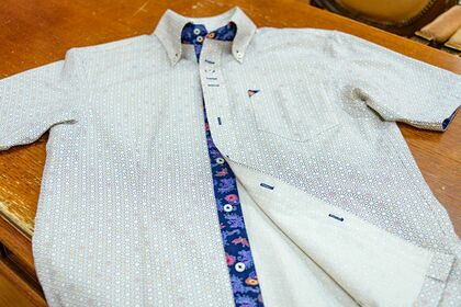 紅型夏シャツ。ボタン部分のさりげない紅型のあしらいがポイント。県内外から注文が寄せられ、贈り物でも人気（写真／藤井千加）