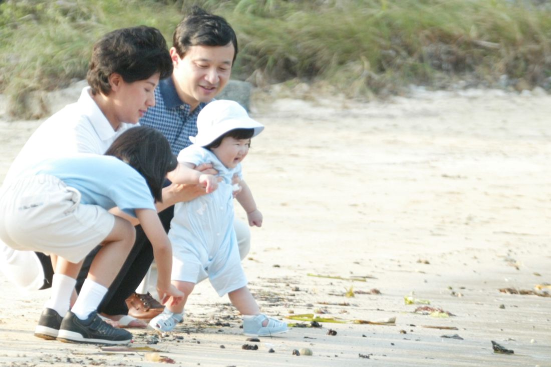 初めて訪れた須崎御用邸内の三井浜で遊ばれる生後8か月の愛子さま。雅子さまに支えられながらニコニコ笑顔で浜辺デビュー　写真／JMPA、『週刊女性』写真班