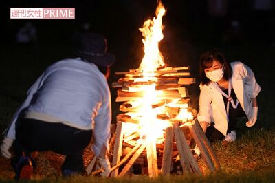 夜にはキャンプファイアにご参加。燃えるたいまつから、薪へ点火された。参加者たちとおそろいの水色のネッカチーフを巻かれた佳子さま