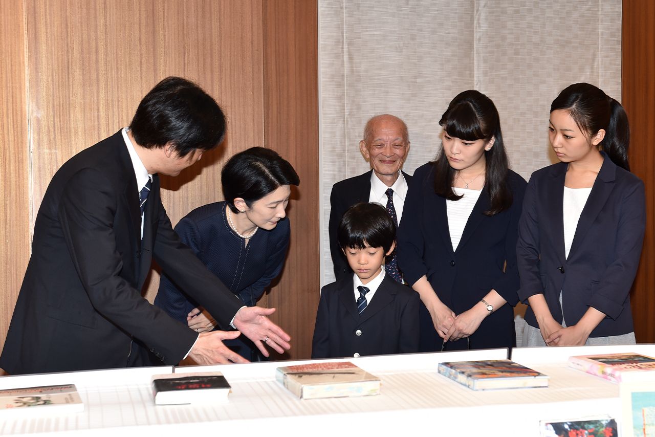 『対馬丸』の絵本をご覧になる悠仁さまの背後には山本和昭さんの姿も。秋篠宮さまは身振りを交えてご説明を（'14年8月）