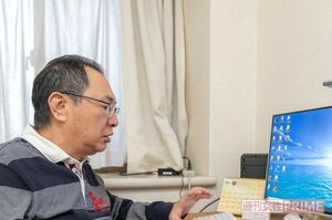 書籍化を目指し、パソコンに向かって左手一本で闘病記を入力する　撮影/佐藤靖彦