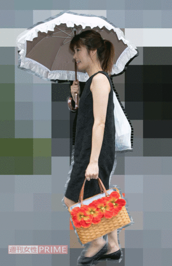 手にはフリルつきの日傘と大きな花飾りがあしらわれたカゴバッグが。独特なファッションセンスは健在のようだ