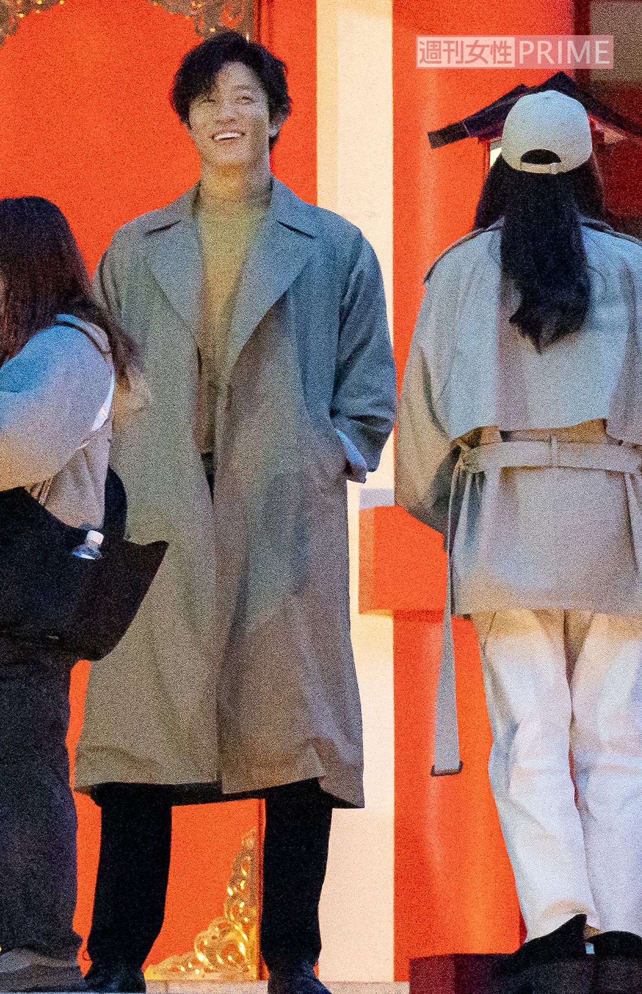 2月中旬、『シティーハンター』ロケでにこやかな笑顔を浮かべる鈴木亮平。ベージュのロングコートを着こなし、抜群のスタイルが際立っていた