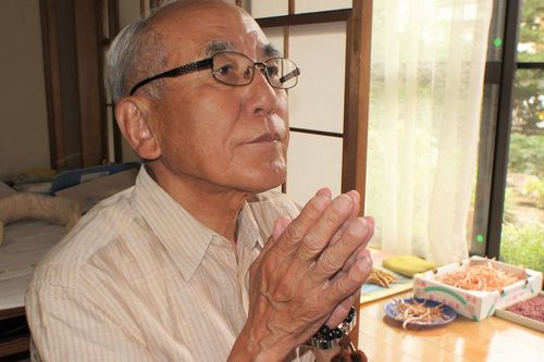 仏壇に手を合わせる南一成さん。表情が引き締まる