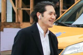 ワイヤレスイヤホンを装着し、徒歩で出勤する圭さん（'22年4月）　写真／共同通信社