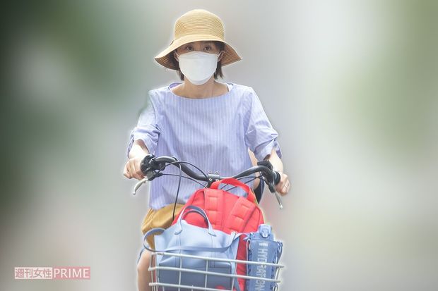 長男のリュックをカゴに入れて自転車をこぐ山口もえ（'21年8月）