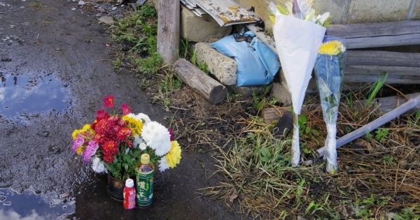  叶野宅の門前に供えられた花たち。不明の３人は広く好かれていた