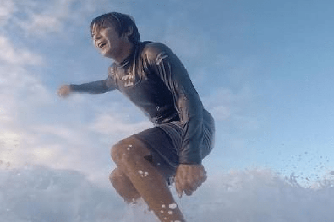 ハワイで趣味のサーフィンをしているところ