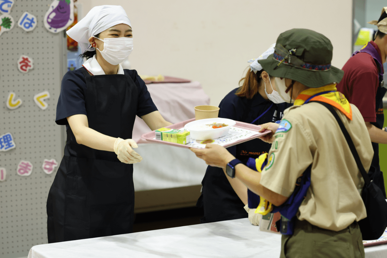 8月10日、「日本アグーナリー」で、全国から参加した子どもたちに笑顔でカレーを配膳される佳子さま