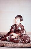 '63年2月、3歳をお迎えになった浩宮さま(当時)。鶴、橘、滝が刺繍でほどこされたお着物である『落滝津文様』の『黒紅綸子縮緬振袖』をお召しに。