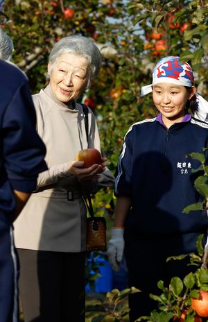 りんごを受け取り、重さを確かめるようにされながら、中学生たちと交流された（11月17日）