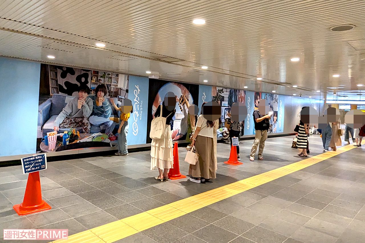 渋谷駅地下通路に展示されたKing & Prince『なにもの』巨大広告と記念撮影をするファン