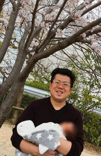 長男を抱き、笑顔の橋本崇載容疑者