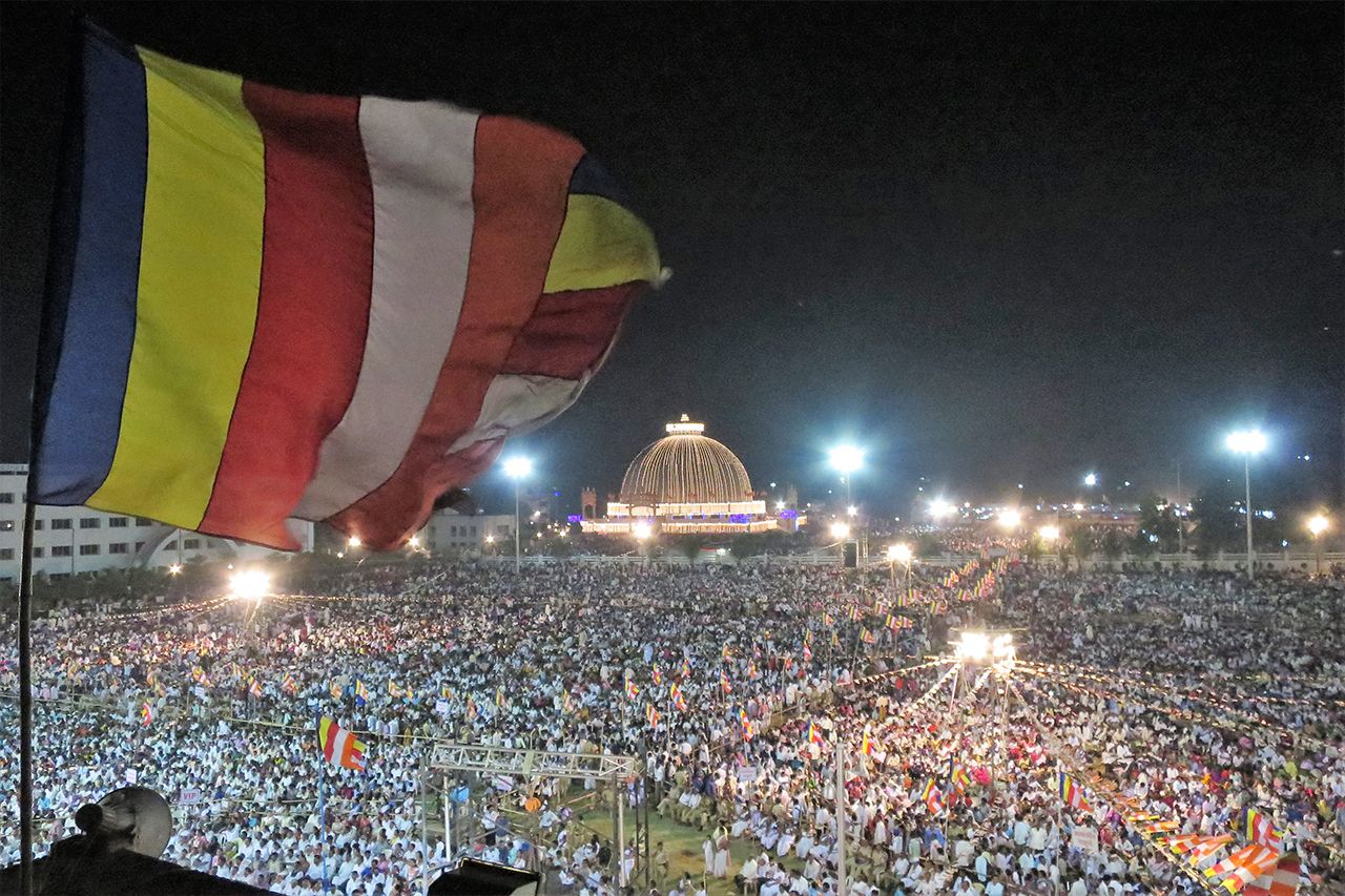 仏教旗がはためく夜の改宗広場。インド全土から仏教徒や改宗希望者がやってきて、多くの人が会場で寝泊まりする　撮影／白石あづさ