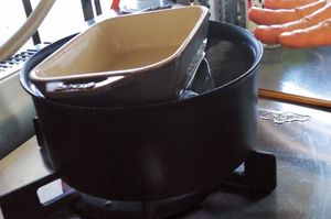 肉が浮いて湯から出ないように、皿などで重しをする