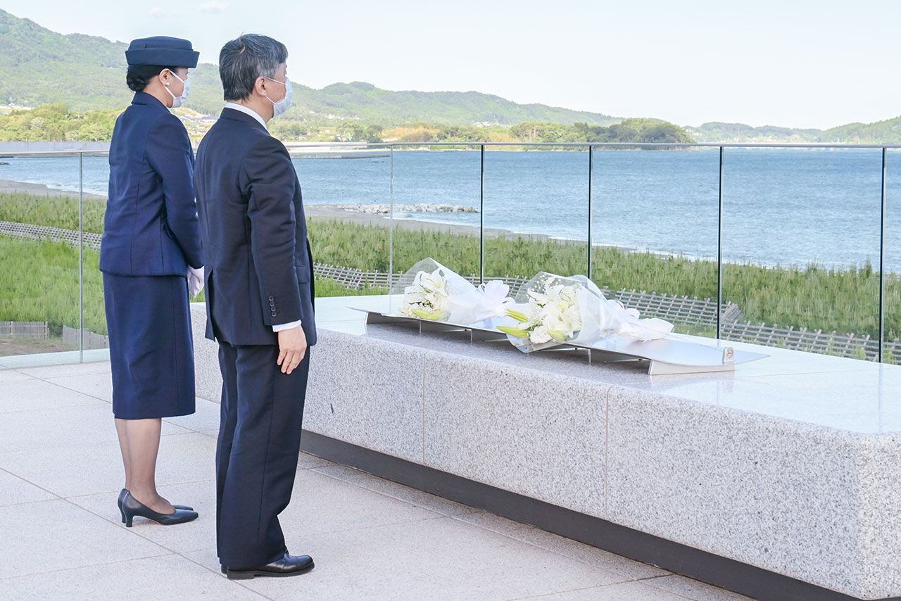 高田松原津波復興祈念公園内、防潮堤の上に設置された『海を望む場』で供花をされた両陛下。花束は白いユリやかすみ草　撮影／JMPA