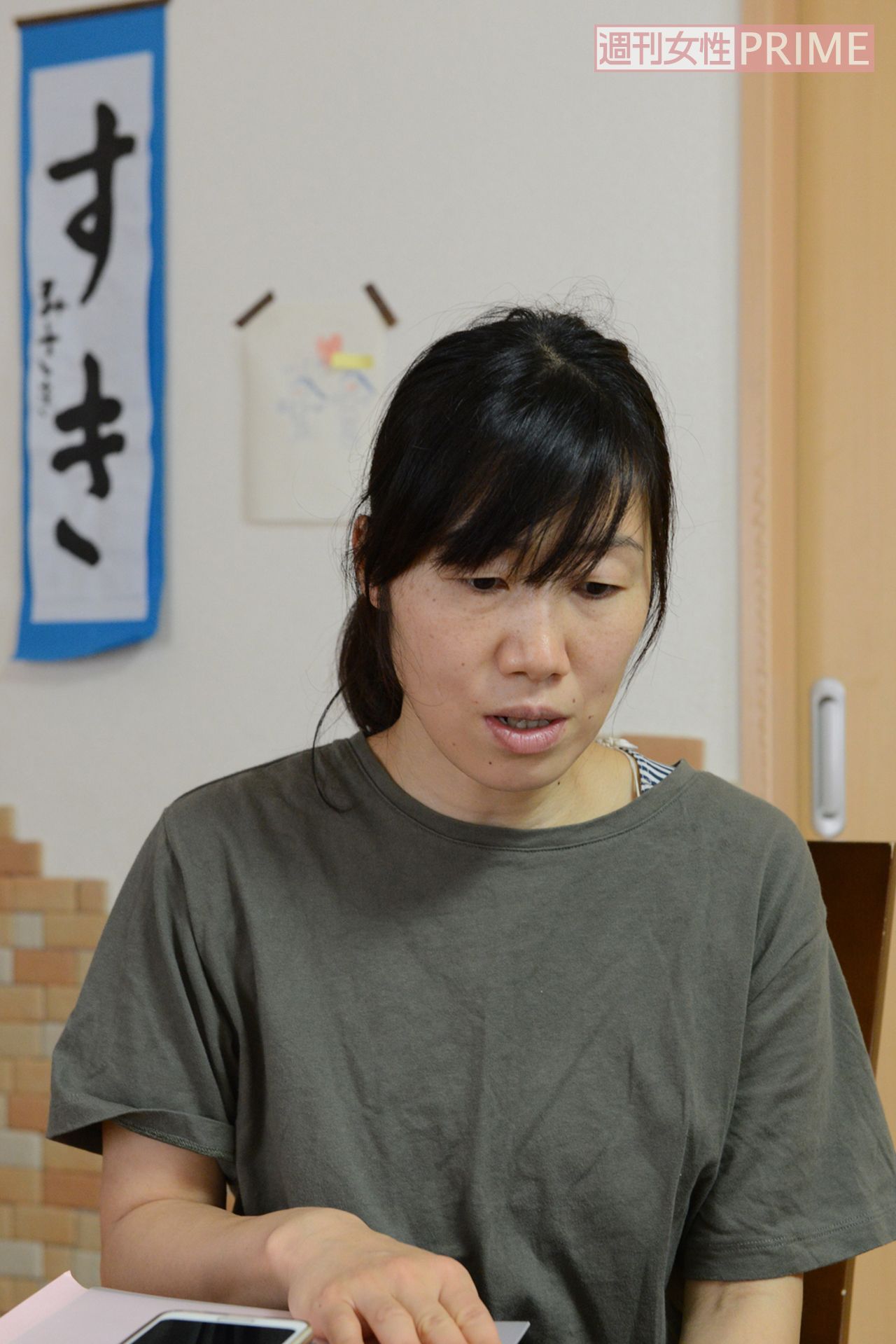 自宅で取材に応じてくれたとも子さん。後ろには美咲ちゃんが書いたお習字の「すき」の文字が……