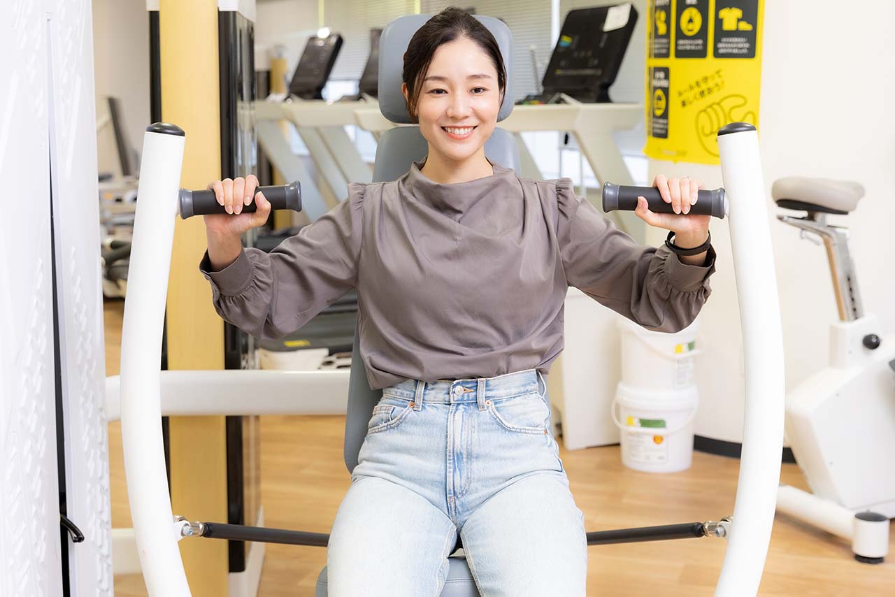 チェストプレスのマシンでトレーニングする千春さん