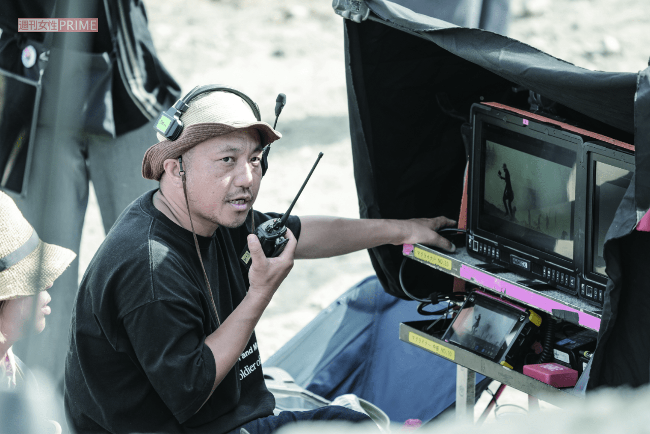 『十一人の賊軍』の撮影現場。爆破の轟音と血しぶきが飛び交うオープンセットの中、鋭い視線でモニターをチェックしながら白石は、「ここに来る山道がワクワクした道に見える」