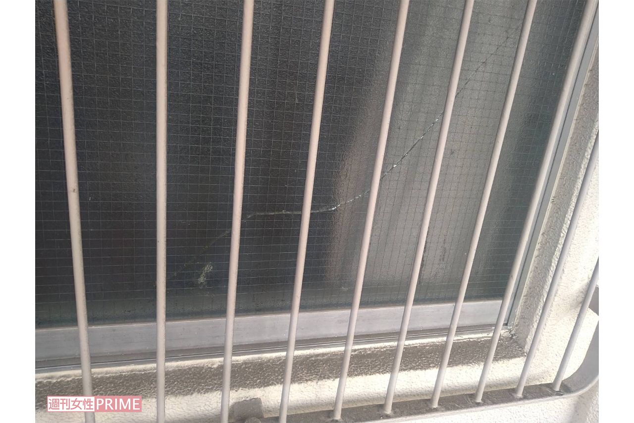 事件現場となったマンションの一室。窓ガラスにヒビが入っていて