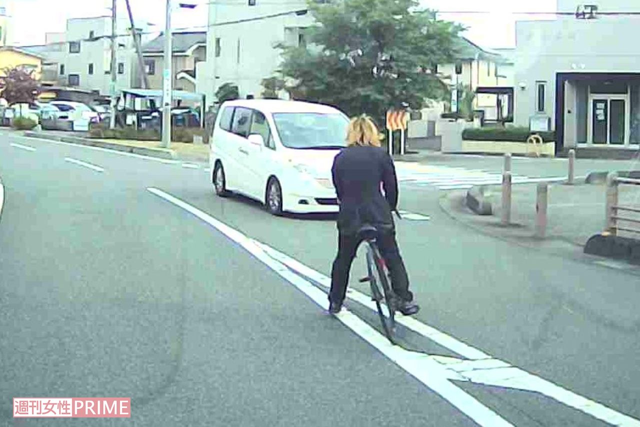 事件直前、対向車の前に自転車で飛び出す成島明彦容疑者（目撃者提供）