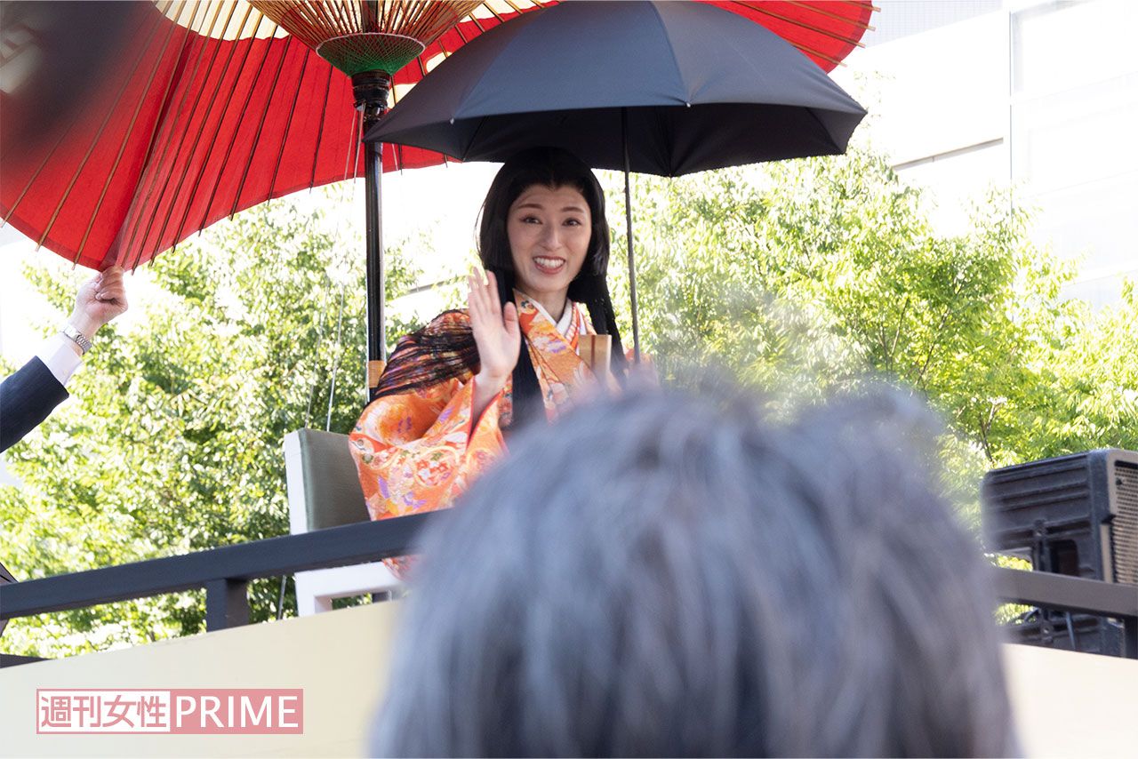 和傘に加え日傘をさして移動車に乗る栗山千明の周りには、撮影自粛を呼びかけるスタッフが