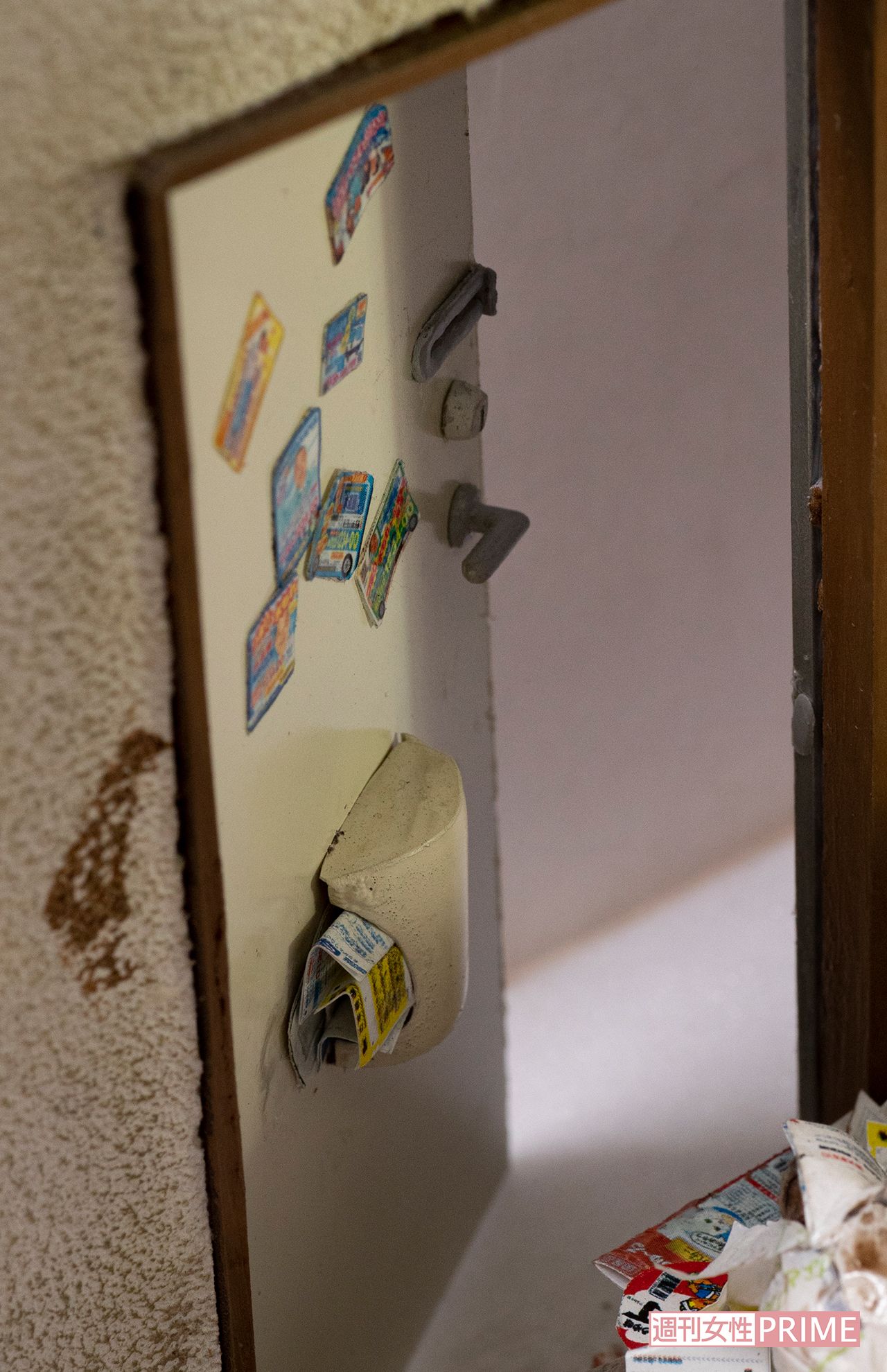 玄関の扉には、水道工事などのマグネット広告が。これらも捨てずにとってあるケースが多いと小島さん