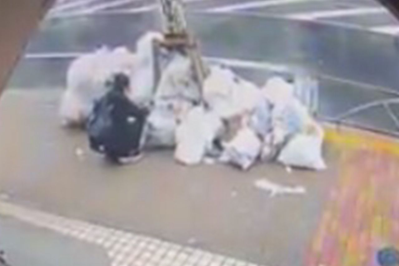 男がしゃがんでゴミ山に手を突っ込んだ後、白煙と炎が（放火2件目の防犯カメラ映像より）