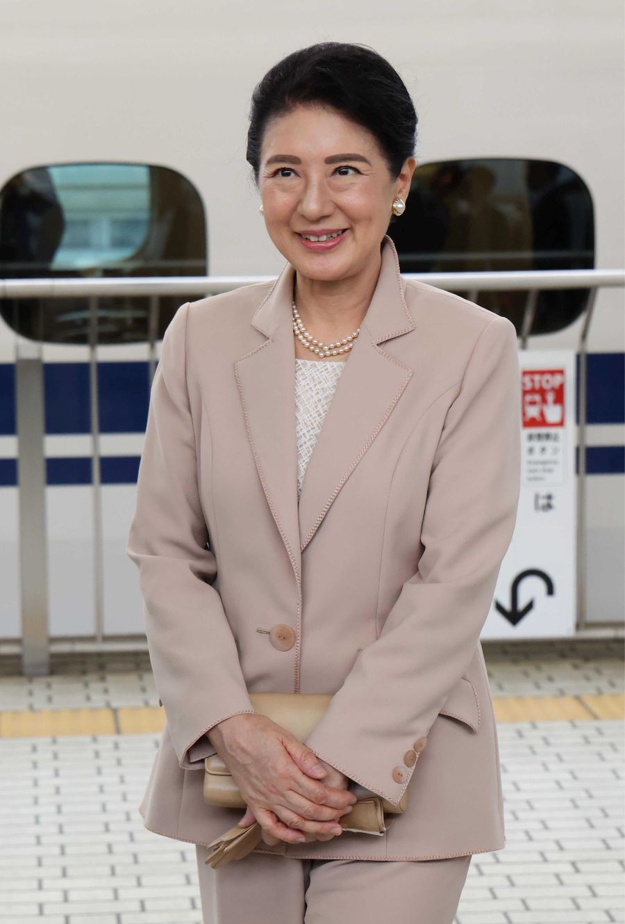 ピンクベージュのパンツスーツの雅子さま